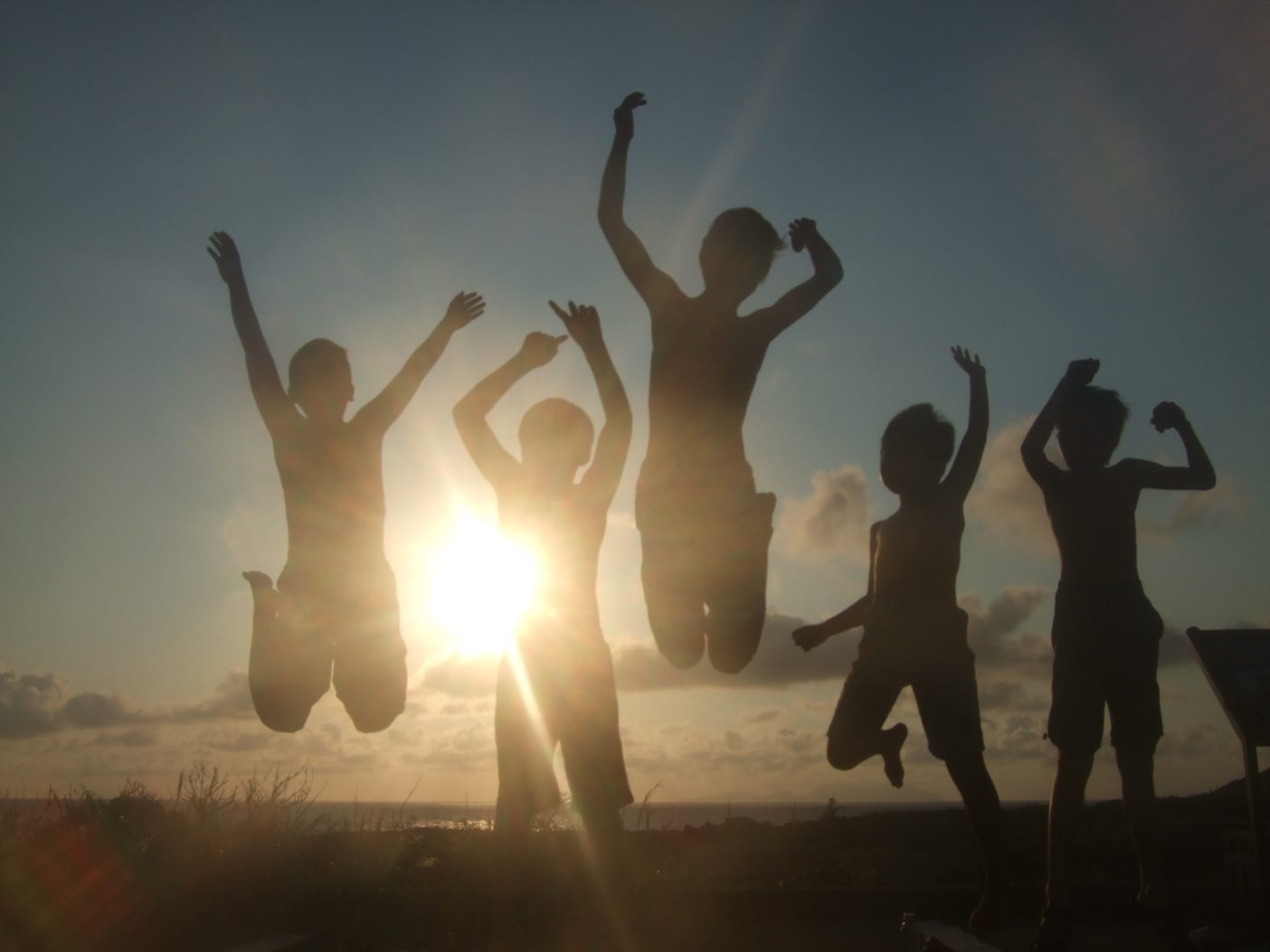 1日の終わり、夕日を背にジャンプする子供たち。写真:松宮愛
