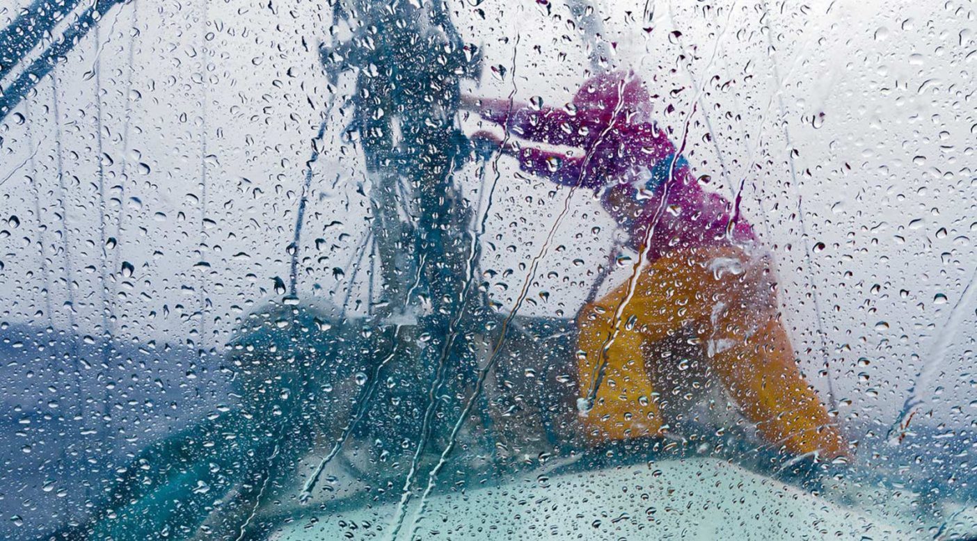 急速に移動する南太平洋のスコールの強風に捕まり、スウェル号のセールをリーフするためにマストへ向かうリズ・クラーク。Photo: Tahui Tufaimea