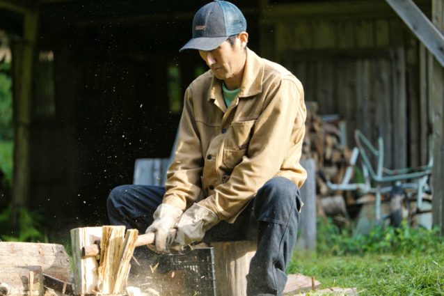 森林の整備作業で出た間伐材を譲り受け、薪にする。最近は師匠について山に入ることが何より楽しい、と田中さん。写真:五十嵐 一晴