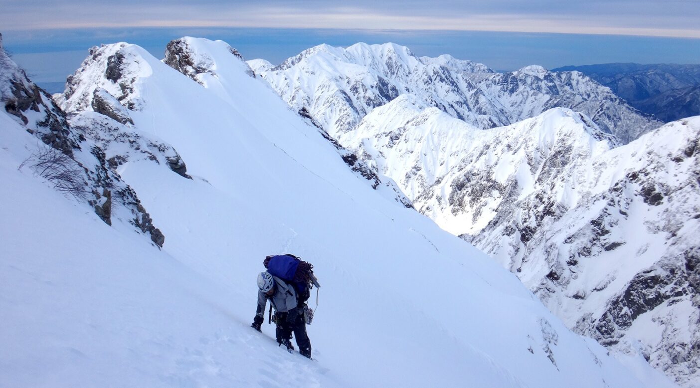 越えてきた膨大な山並みを背景に、三ノ窓へ向かう。写真:和田 淳二