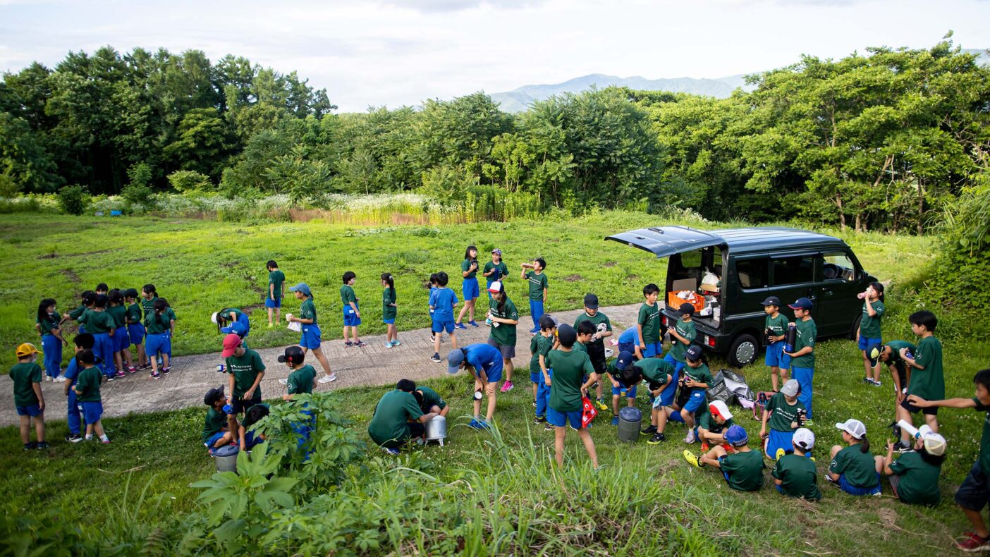 小学校近くにある里山でトレーニング。休憩タイムのドリンクは運営の大人たちが用意する。写真:藤巻 翔